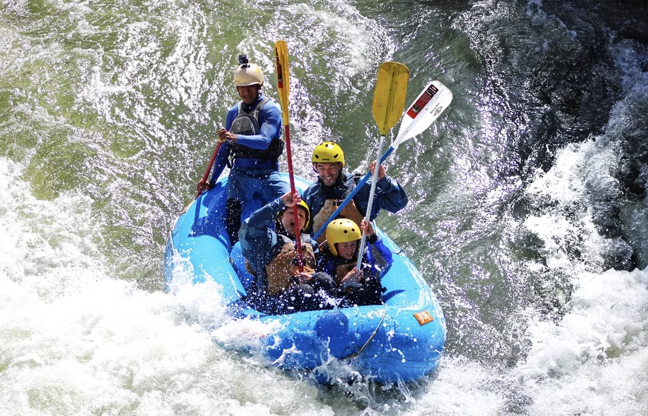 Rafting crew paddling through whitewater rapids on the Chili River